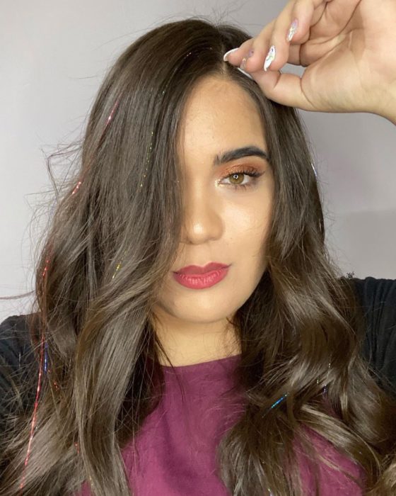 Chica usando extensiones de glitter en el cabello