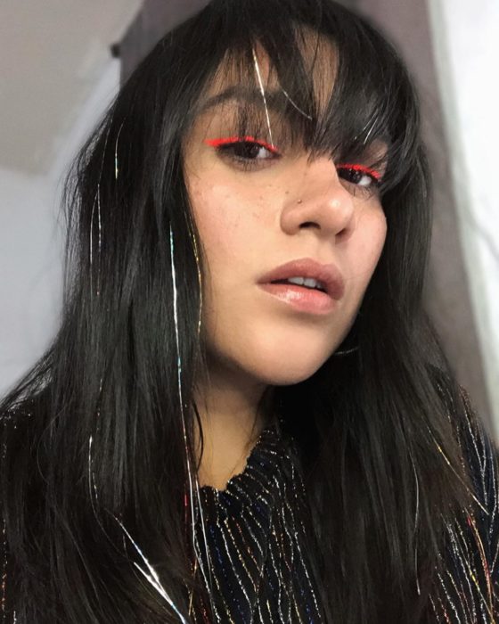 Chica usando extensiones de glitter en el cabello