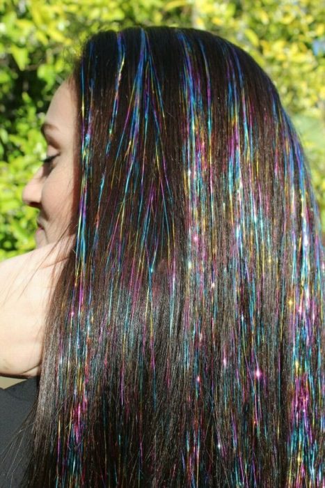 Chica usando extensiones de glitter en el cabello