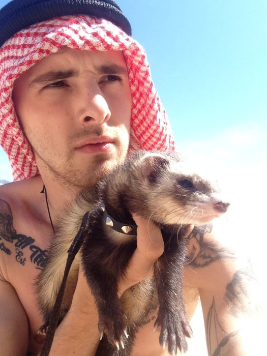 Chico posando junto a su hurón en una foto