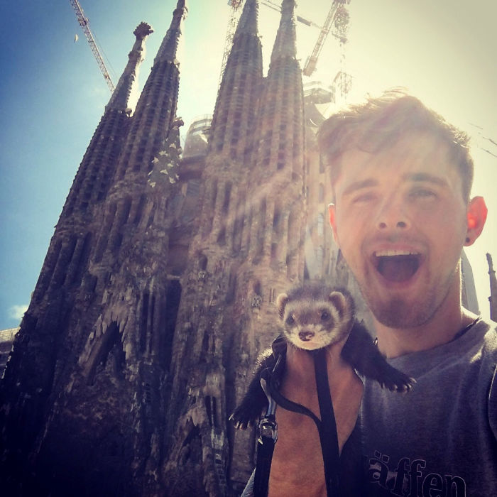 Chico posando junto a su hurón frente a una iglesia en París