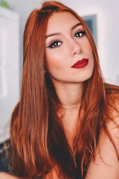 Chica con el cabello de color cobrizo y reflejos en color naranja