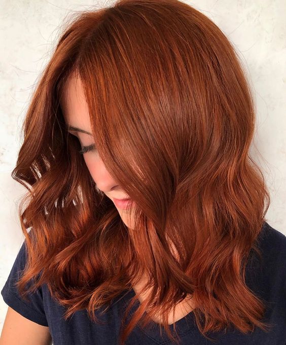 Chica con el cabello de color cobrizo y reflejos en color naranja
