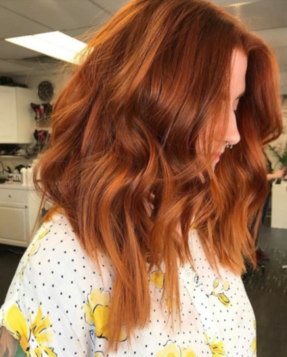 Chica con el cabello de color cobrizo y reflejos en color naranja