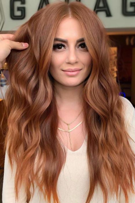 Chica con el cabello de color cobrizo y reflejos en color naranja