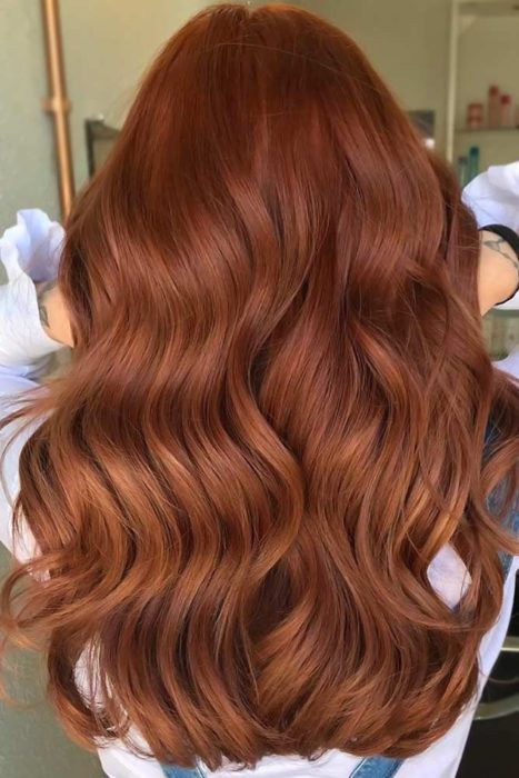 Chica con el cabello de color cobrizo y reflejos en color naranja