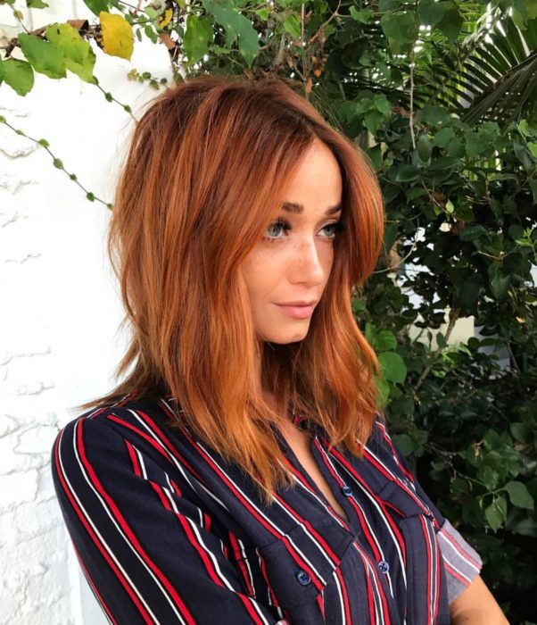 Chica con el cabello de color cobrizo y reflejos en color naranja