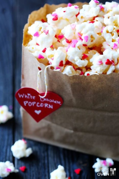 Palomitas cubiertas con chocolate blanco y confituras de colores rosa y rojo