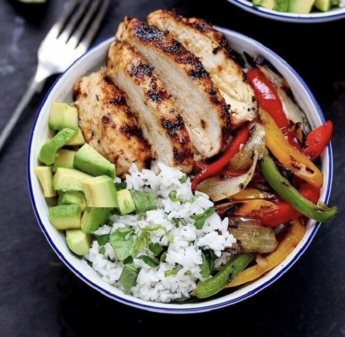 Cena con proteína, acompañada de arroz, aguacate y pimientos asados