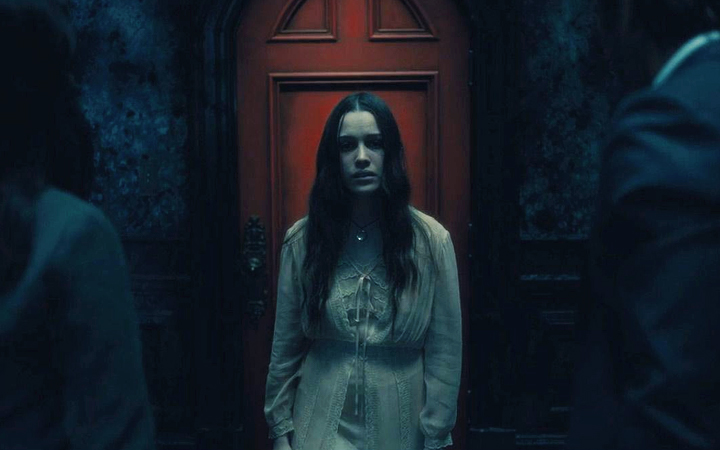 Nell Crain frente a la puerta roja en The Haunting of Hill House