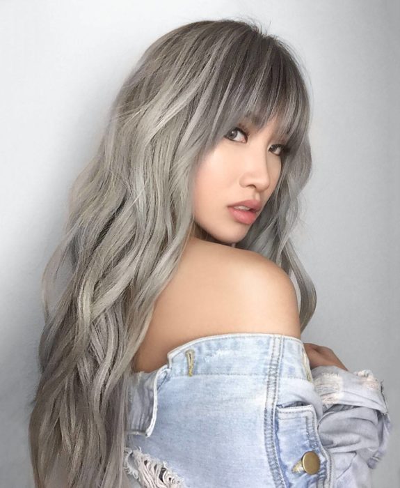 Chica con cabello rubio cenizo platinado y flequillo