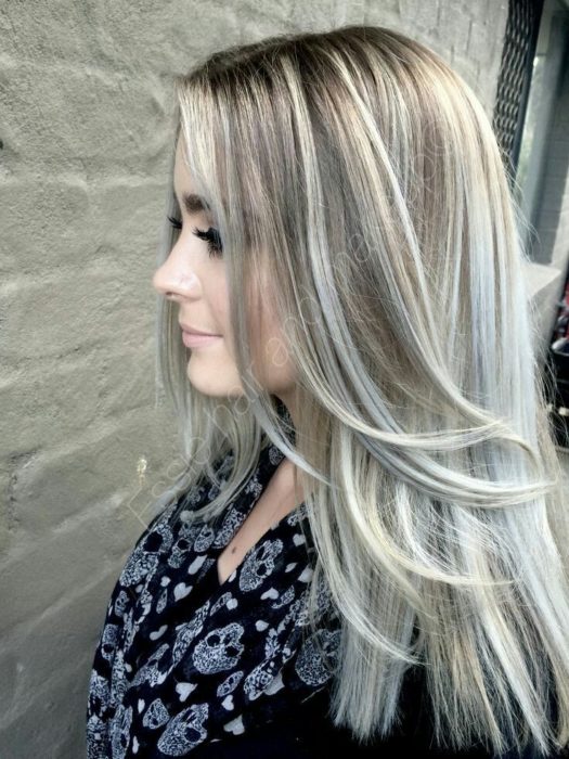 Chica con cabello rubio cenizo y mechas platinadas