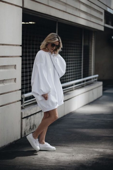Chica con sudadera amplia blanca como vestido