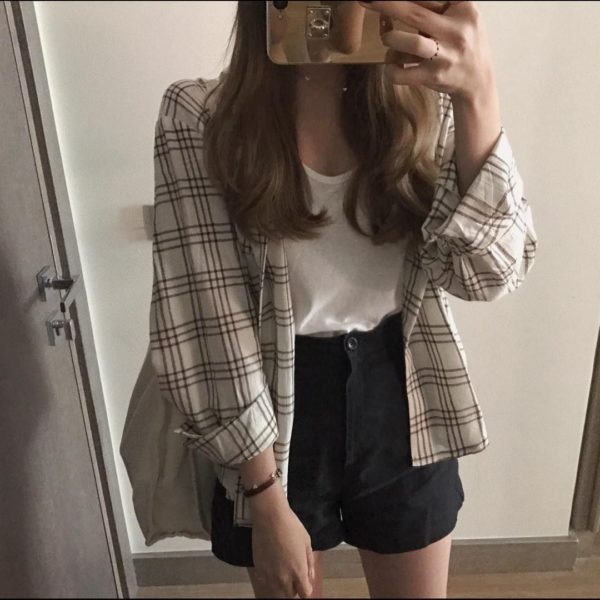 Chica con camisa a cuadros amplia y falda en negro
