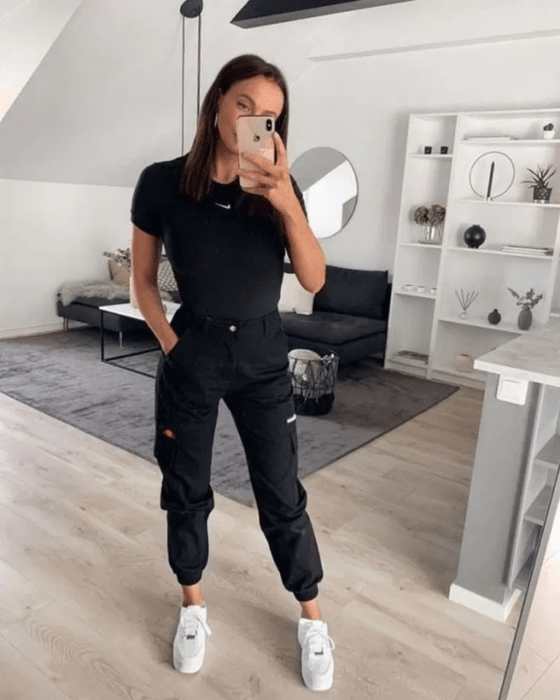 Chica con un jogger negro, blusa negra y tenis