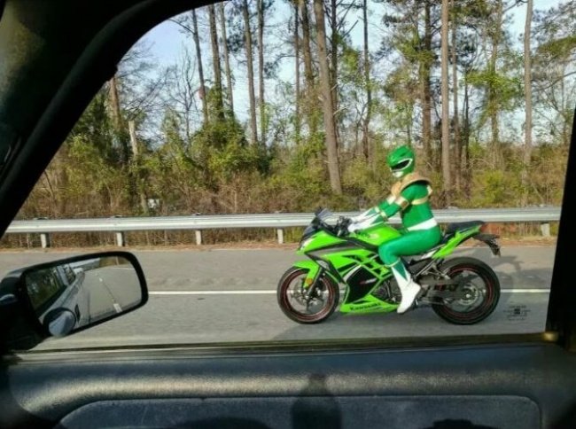 Chico manejando su motocicleta mientras está vestido de Power Ranger