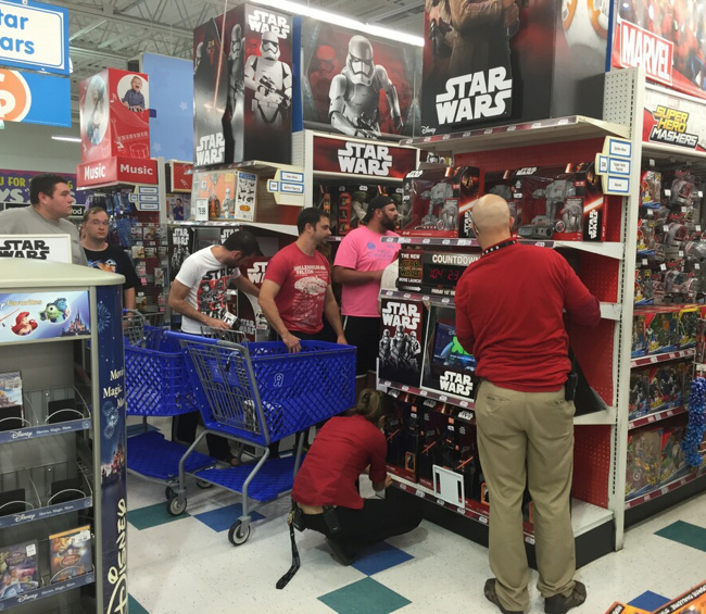 Hombres buscando juguetes en el mueble de Star Wars