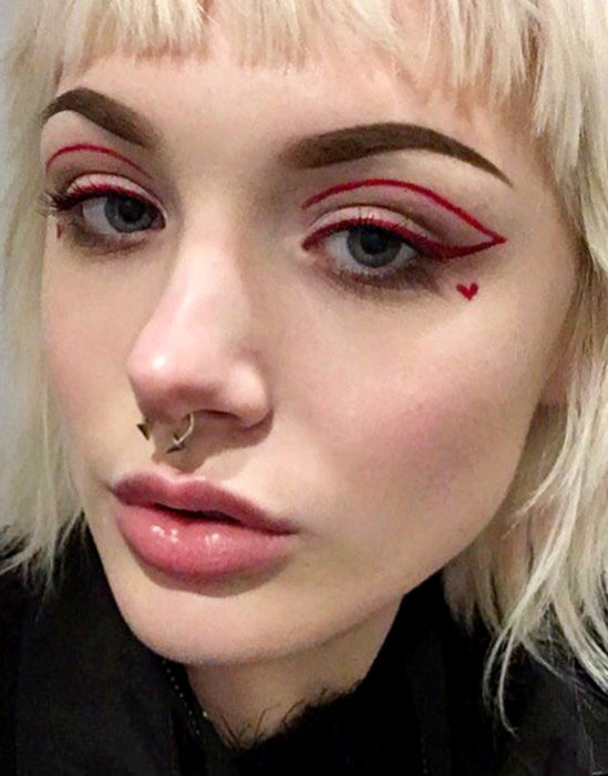 Maquillaje tendencia para el 2020; delineado gráfico o flotante color rojo con un corazón en la mejilla