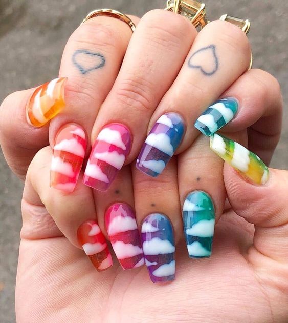 Uñas efecto gelatina de colores con diseño de nubes blancas