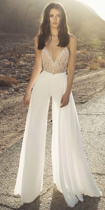 Chica usando un jumpsuit de color blanco con pedrería de cristal en la parte superior
