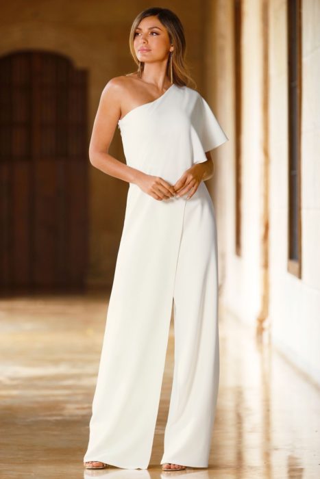 Chica usando un jumpsuit de color blanco con un hombro descubierto