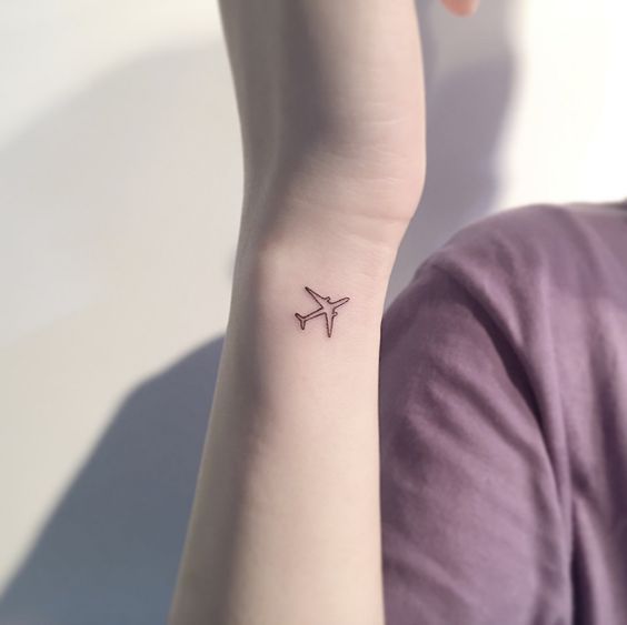 Tatuaje de miniavión en la muñeca
