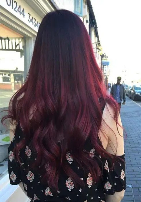 Chica de espaldas mostrando su cabellera larga en tono cherry wine
