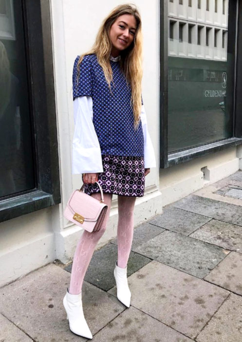 Outfits con medias de colores; chica rubia con medias rosa pastel y botas blancas