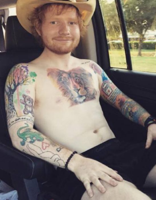 Ed Sheeran mostrando sus tatuajes sin camisa