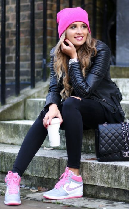 Chica con outfit negro, tenis y gorro rosa fucsia