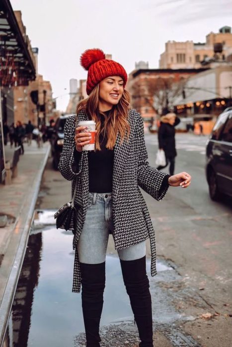 Chica con botas altas, skiny jeans y suéter a cuadros