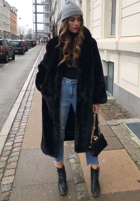 Chica con abrigo negro hasta las rodillas y afelpado