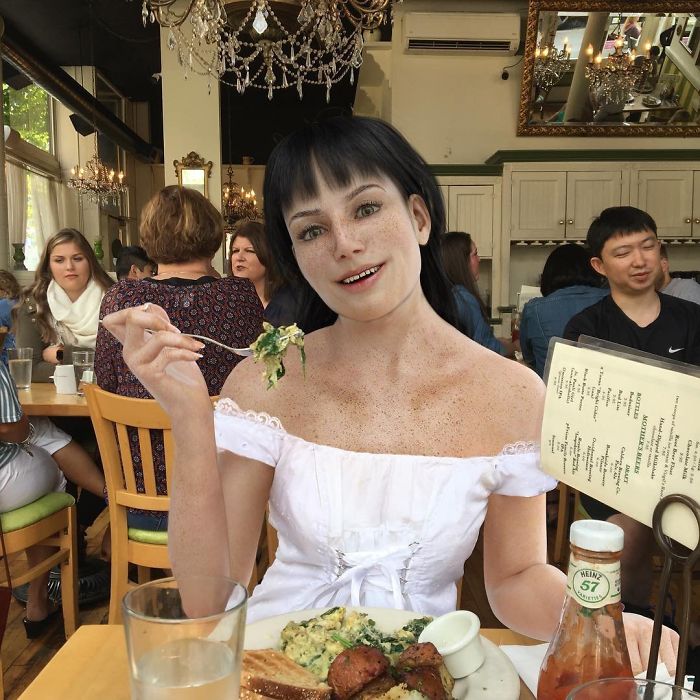 Mujer sentada en un restaurante comiendo y luciendo como un maniquí
