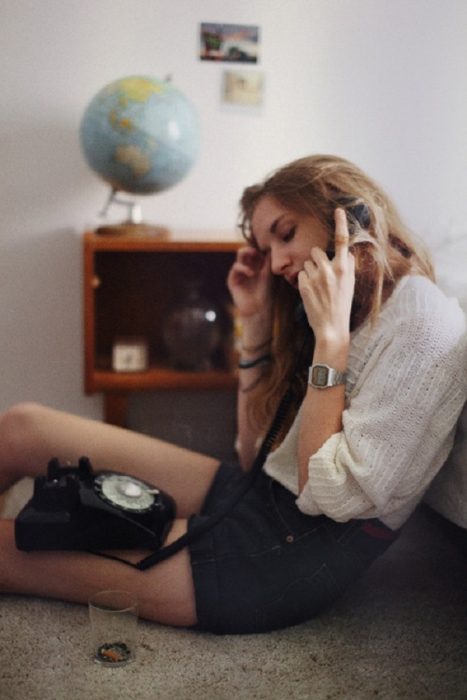Chica llamando por teléfono fijo