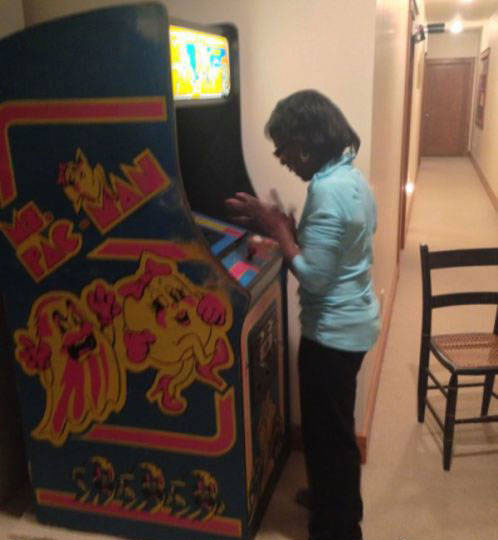 Mujer jugando en máquina de videojuegos arcade
