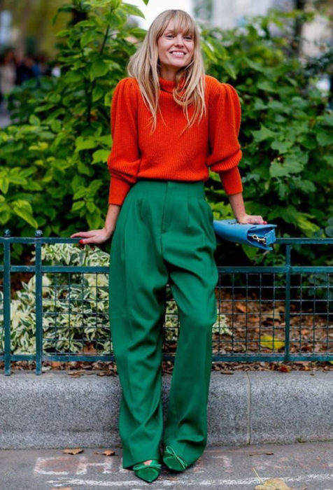 Mujer rubia vestida en colores brillantes, anaranjado y verde