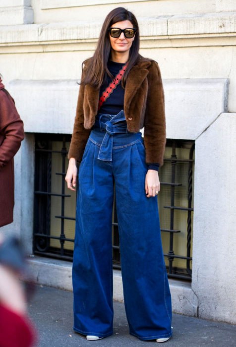 Mujer de cabello castaño con abrigo café y pantalones oversized