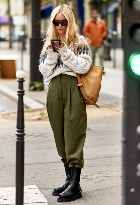 Mujer rubia con pantalones oversized y suéter tejido
