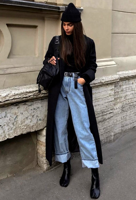 Chica con abrigo negro y botines en un look relajado