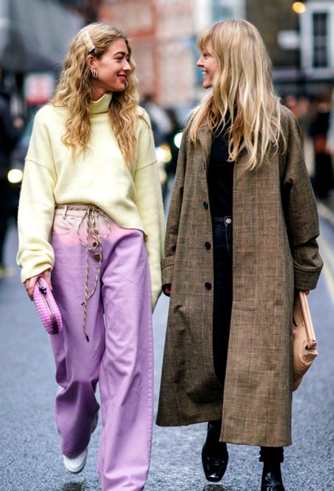Amigas riéndose y disfrutando de la calle con atuendo colorido