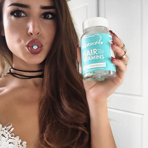 Chica comiendo vitaminas capilares