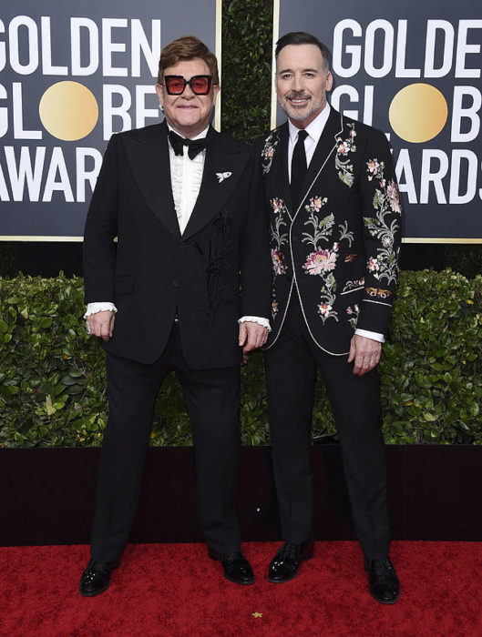 Elton John y David Furnish posando abrazados durante los Globos de Oro 2020
