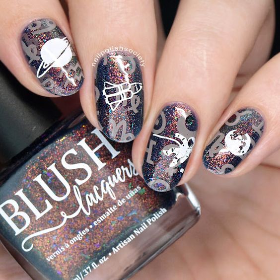 Uñas con destellos en glitters y stickers de astronauta