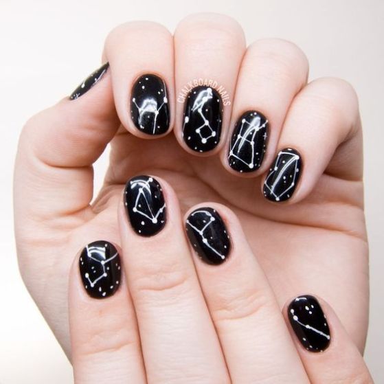 Uñas en negro con diseño de galaxias 