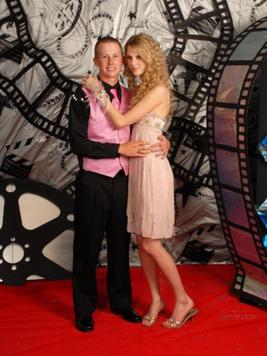 Taylor Swift con vestido rosa y cabello chino lleva a fanático a baile de graduación