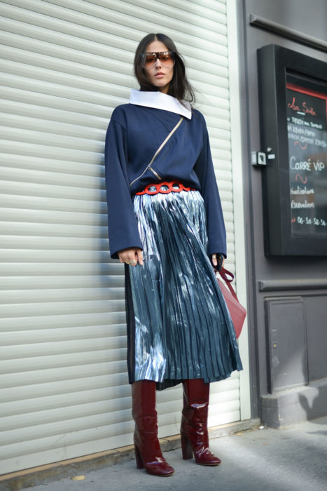 chica con suéter azul oscuro y falda larga plisada azul con toques blancos