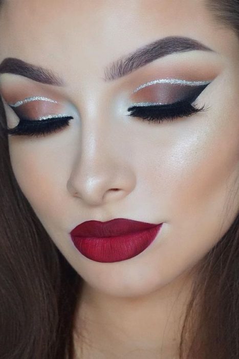 Chica con los ojos cerrados mostrando maquillaje con delineado en glitter