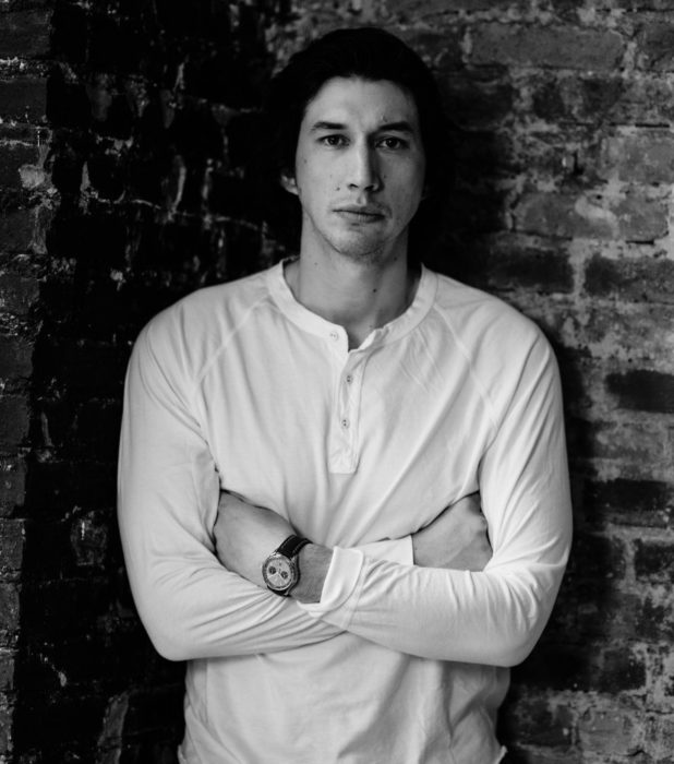 Actor Adam Driver; fotografía en blanco y negro de hombre de ojos oscuros, cabello oscuro, con los brazos cruzados