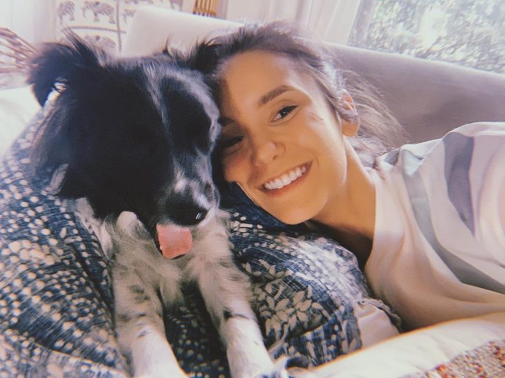 Nina Dobrev recostada junto a su perro Maverick Dobrev 