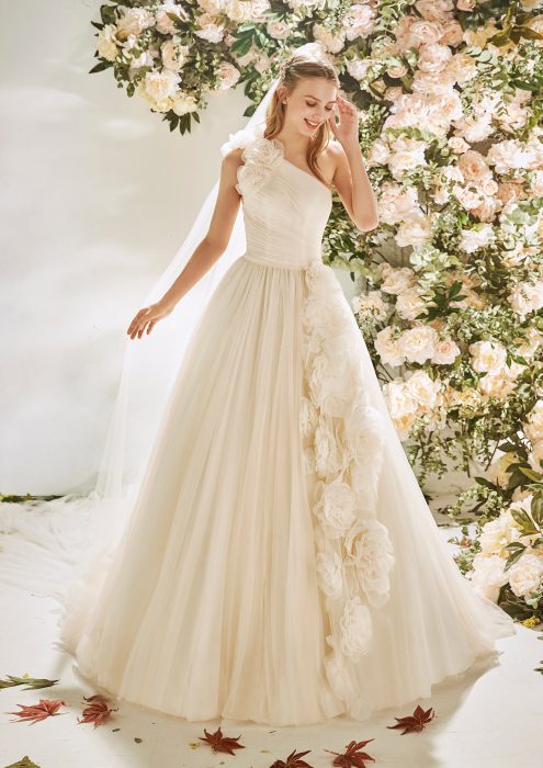 Chica con un vestido de novia blanco con flores en la parte de la falda